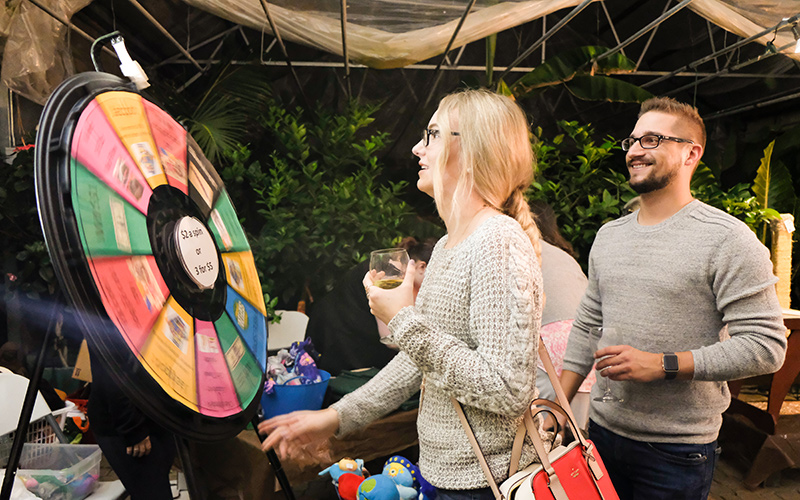 A couple spinning the prize wheel at the silent auction